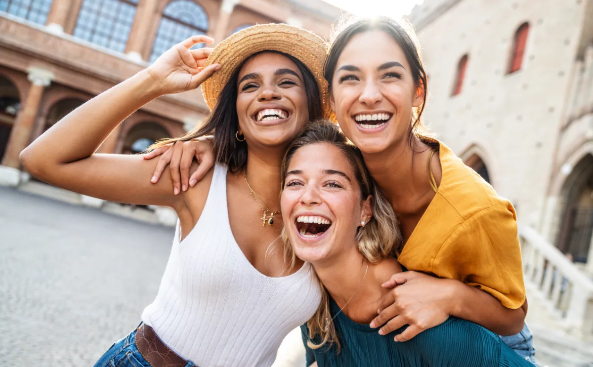 Trois amies rient ensemble lors d'un séjour à l'étranger